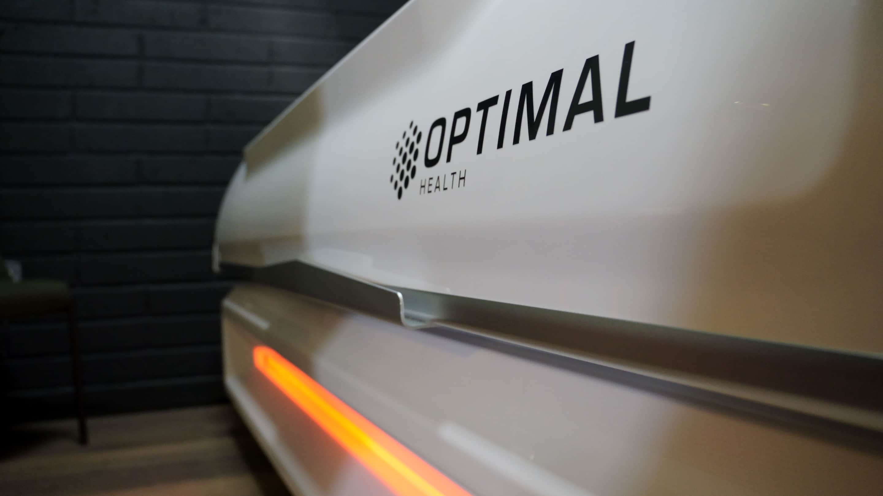Close along the shell of the infrared bed, its orange strip lit against black brick